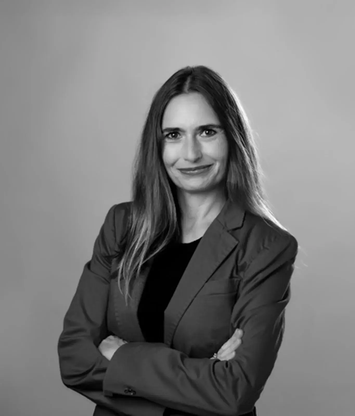 Professional woman in blazer with arms crossed
