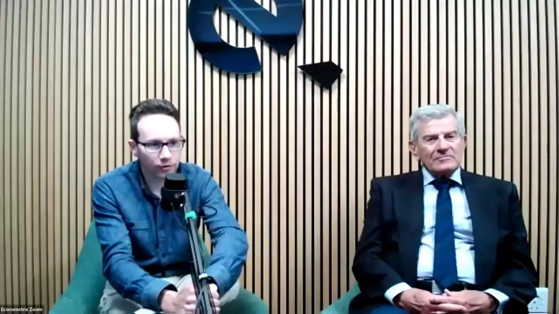 Two men speaking in studio setting.